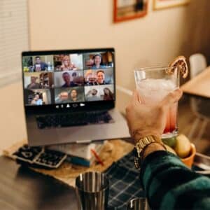 toasting cocktail to screen during virtual happy hour event