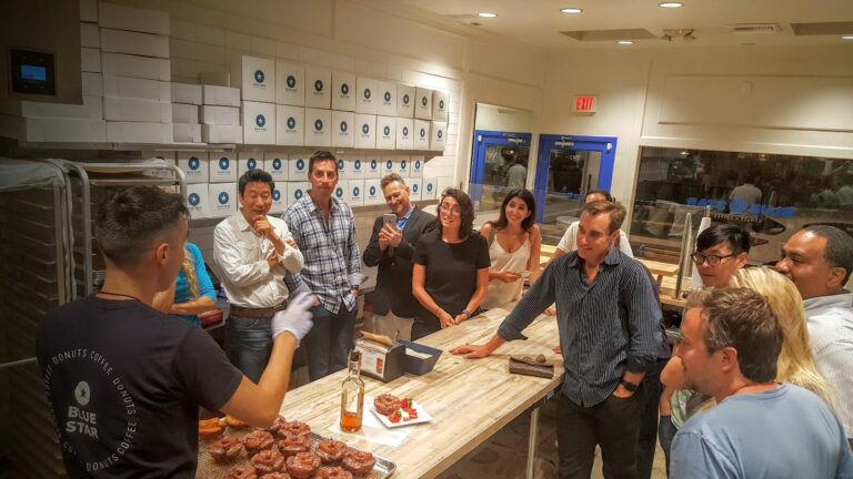 la corporate team building group standing in kitchen at blue star donuts