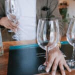 man setting up water glasses for water tasting