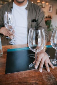 man setting up water glasses for water tasting