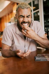 Man biting into lemon slice while flavor tripping on a virtual flavor tripping experience