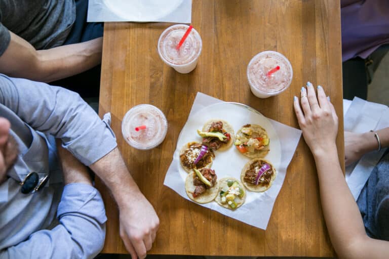 couple sitting at table eating tacos during los angeles date night