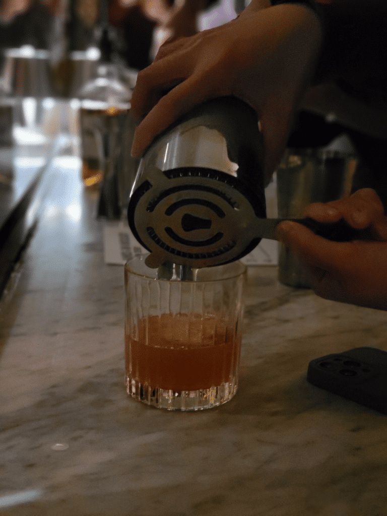 Pouring Brown Derby Cocktail into glass during an Interactive Meal in Los Angeles