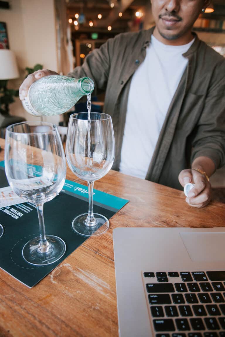 pouring water into wine glass on a virtual water tasting