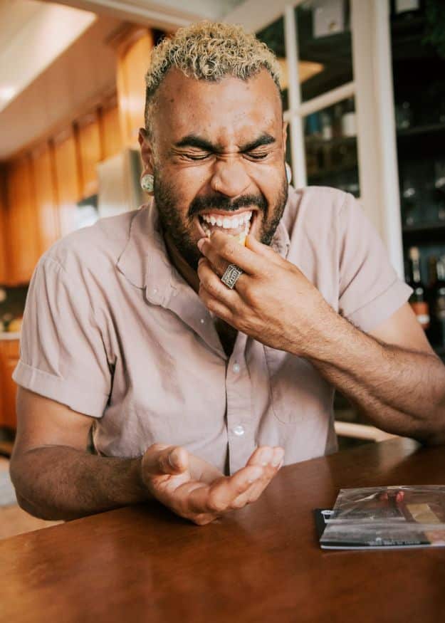 man biting into lemon during tongue twister tasting
