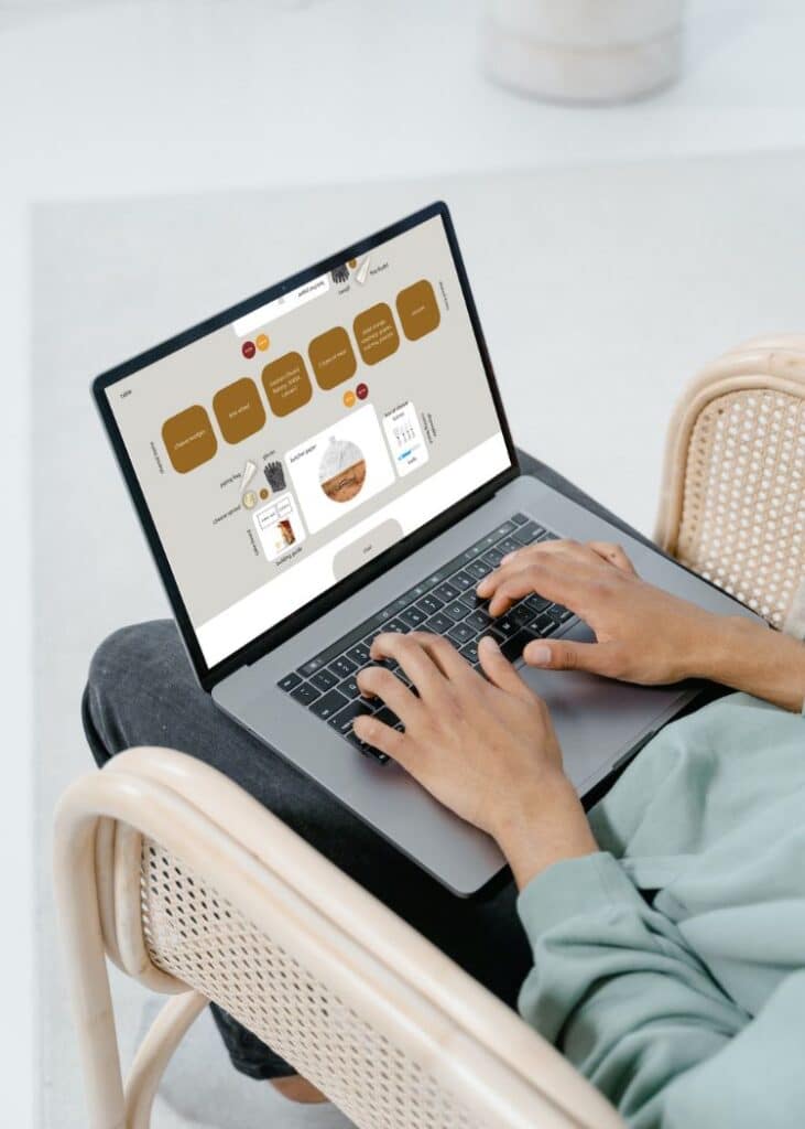 person working on computer of mockup of place setting
