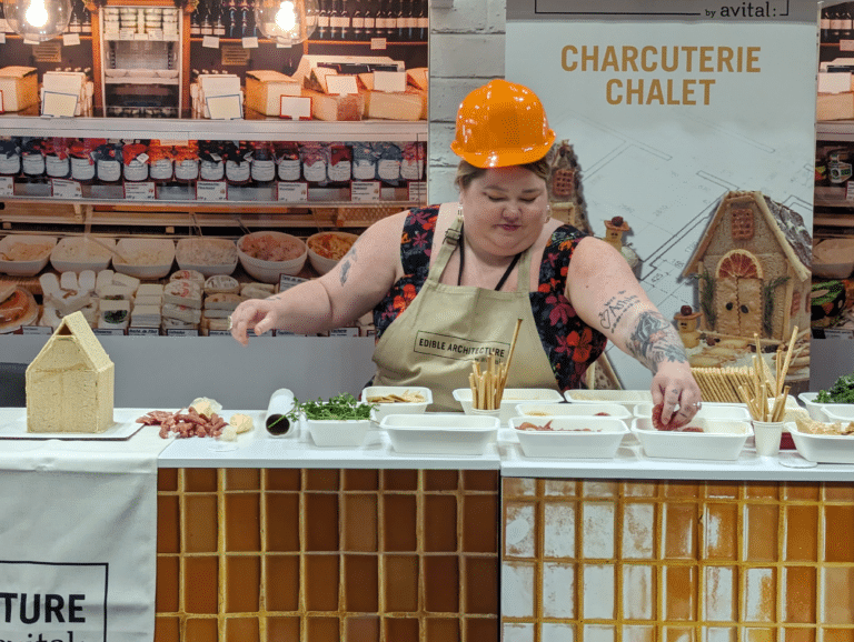 Contestant reaching for meats to decorate charcuterie chalet showdown