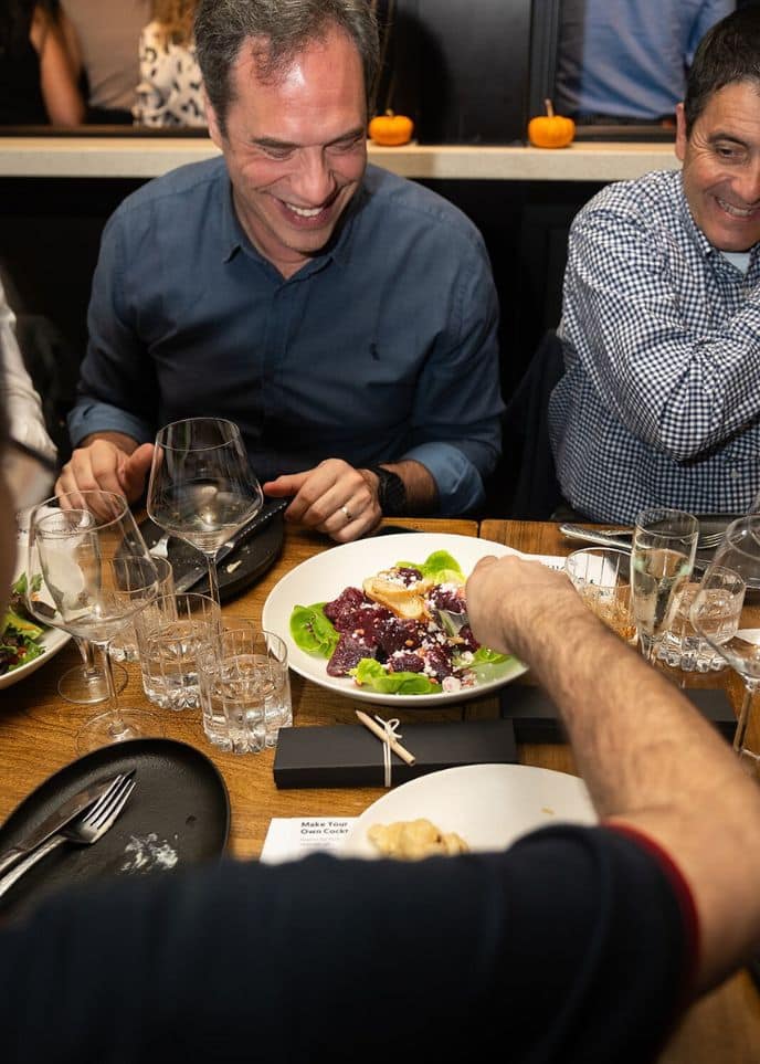 men laughing at table during interactive meal