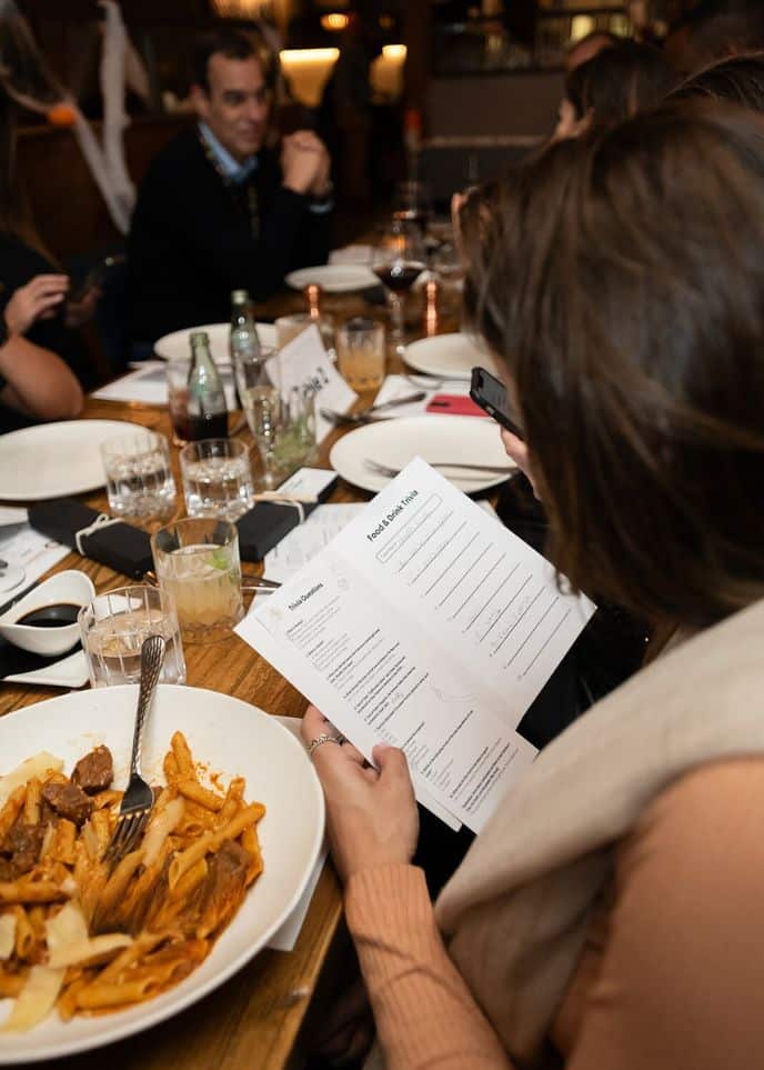 woman reading trivia questions during interactive meal