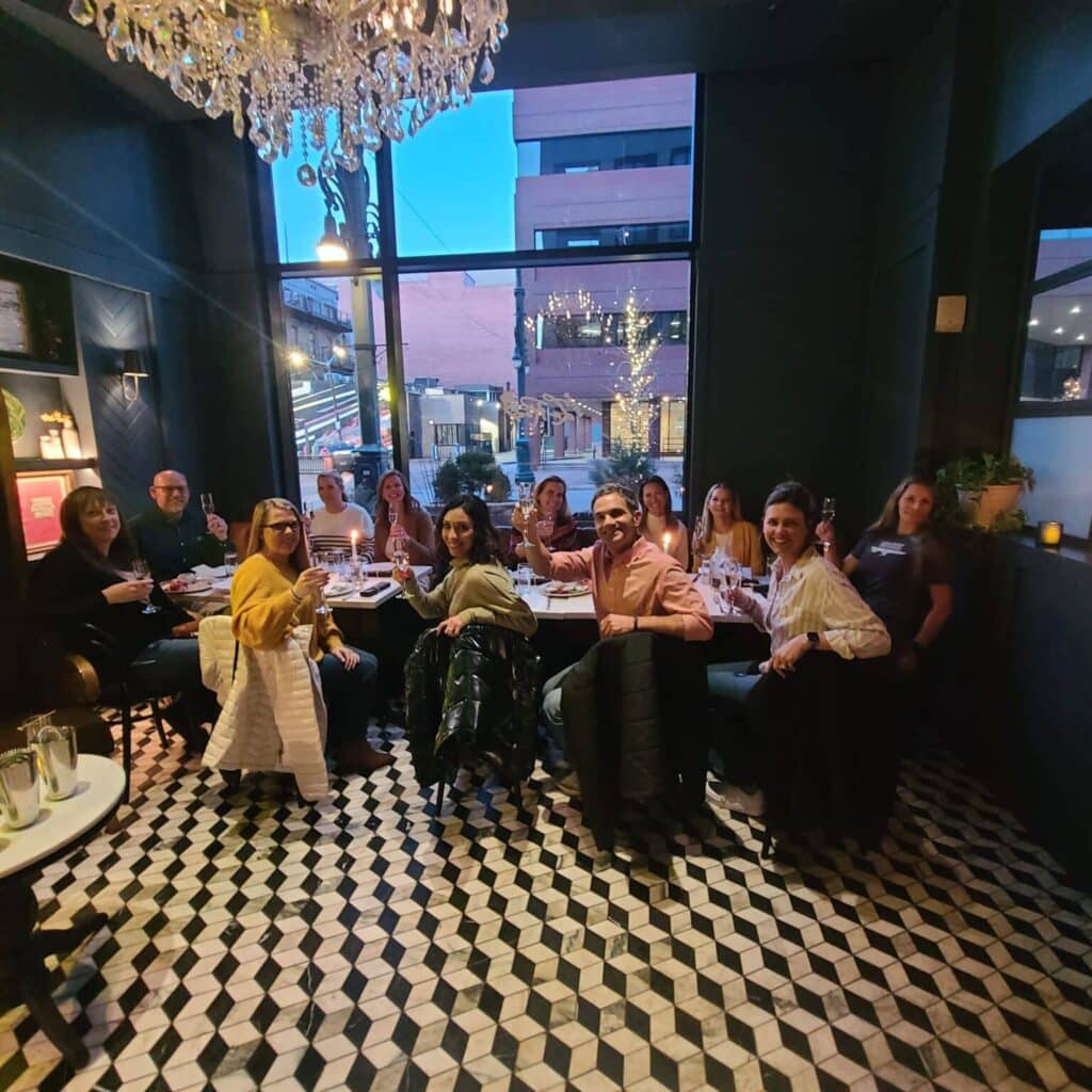 group smiling during avital's interactive meal, best event for large group dining denver