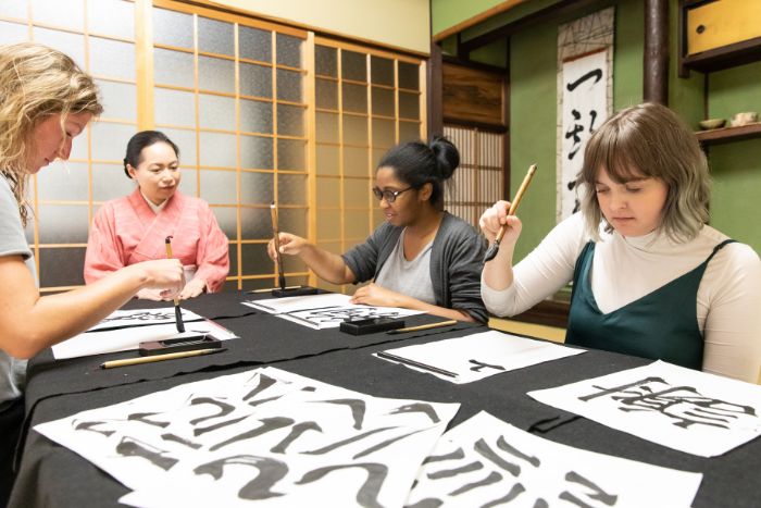 group-doing-japanese-calligraphy-during-team-building-event