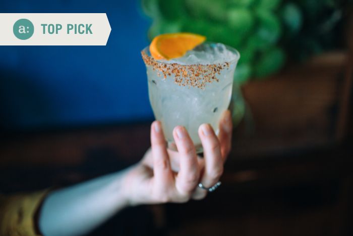 woman-holding-cocktail-during-hands-on-meal