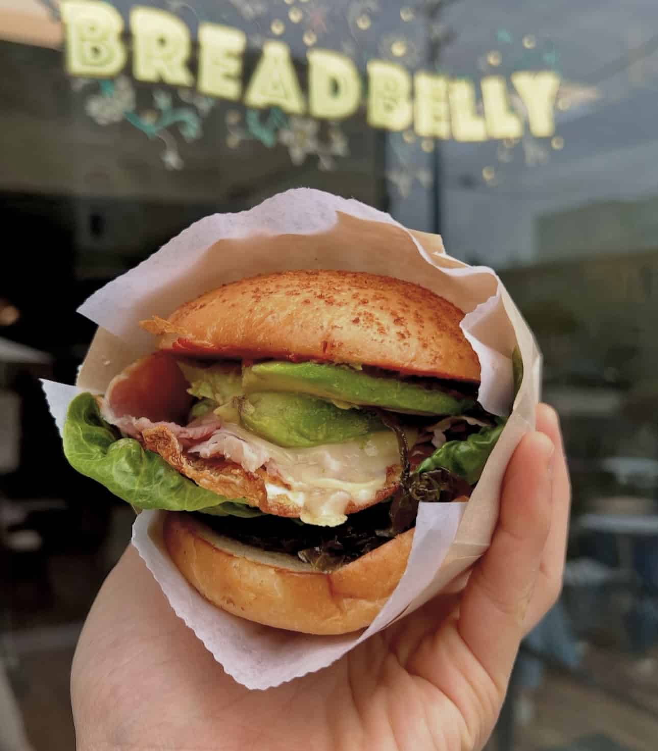hand holding sandwich from breadbelly bakery in san francisco