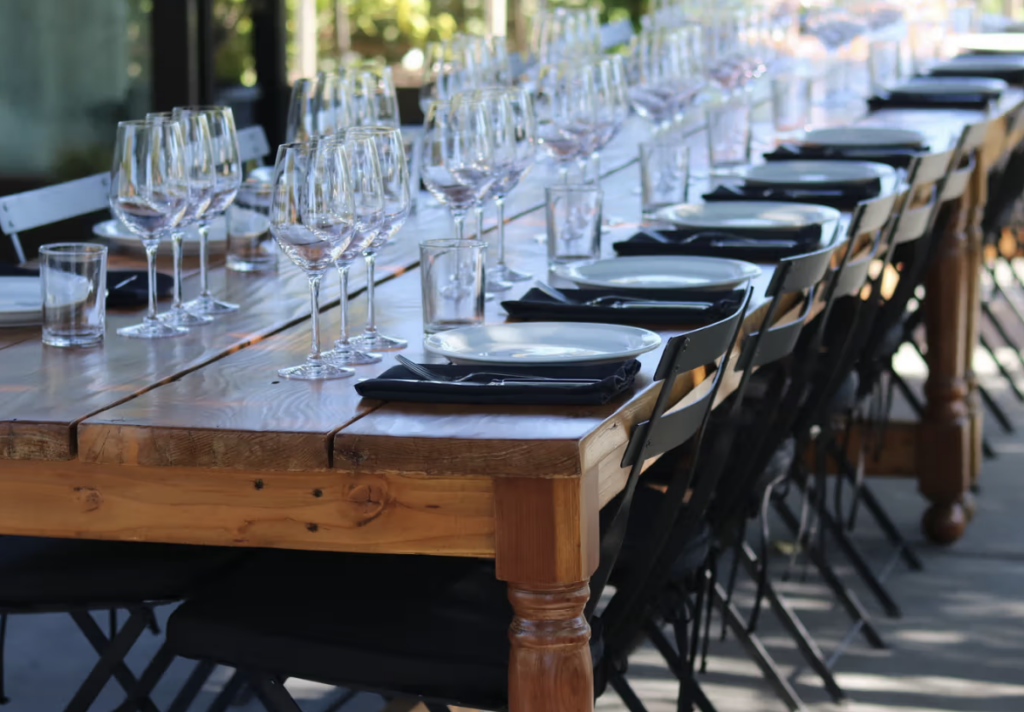 a long wooden table is set with wine glasses at St Clair Winery and brewery