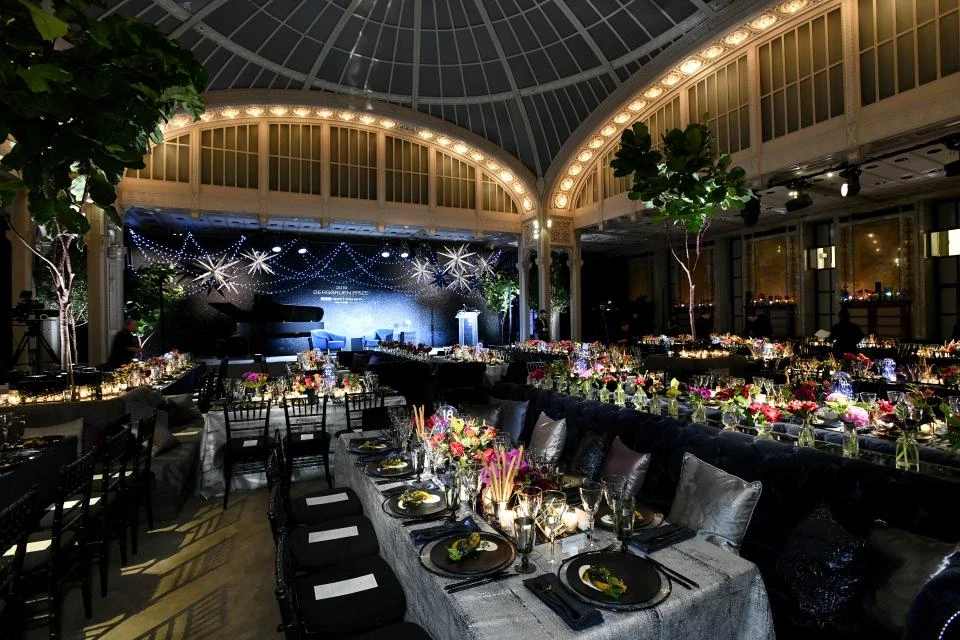 Private event space at the NYPL under big skylights is laid out with tables for dinner