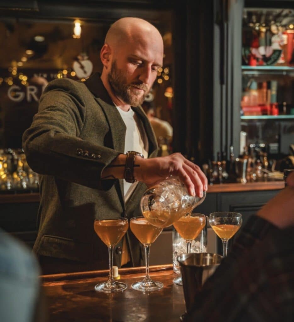 bartender pouring drinks for nyc team building event at the great jones distilling company