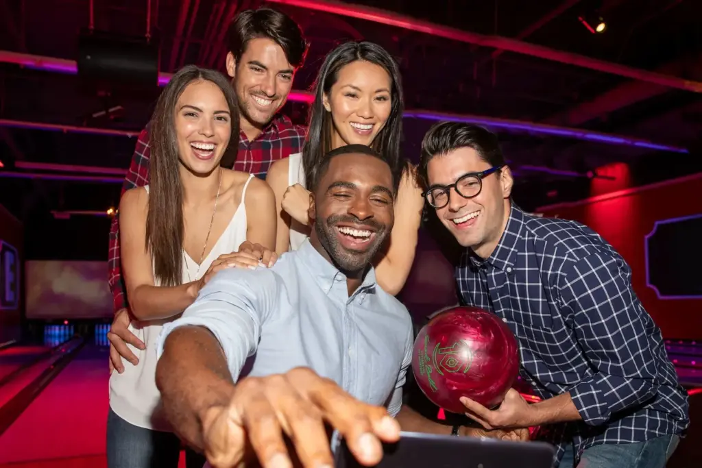 team taking selfie at bowling alley in nyc