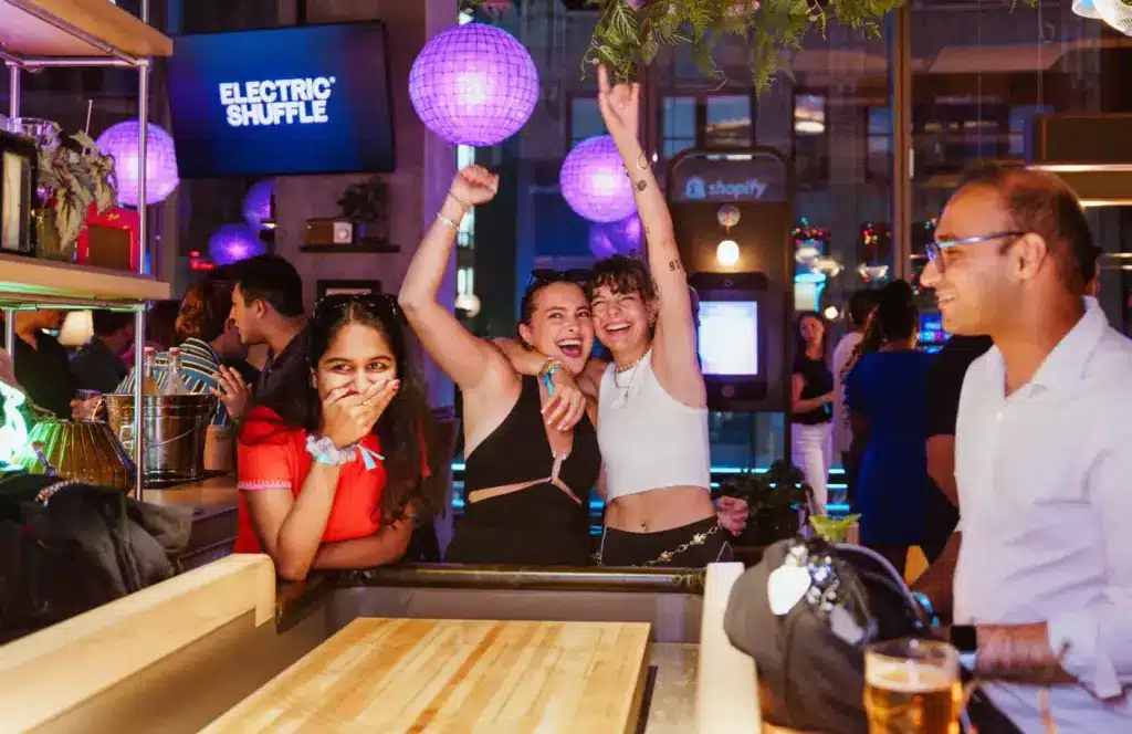 group having fun while playing shuffle board at electric shuffle in nyc