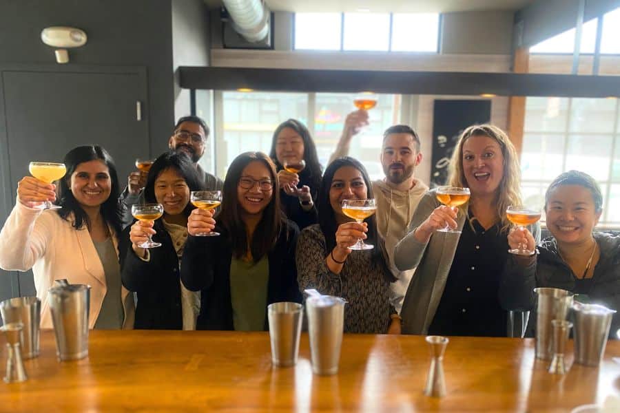 group of people holding cocktails and smiling after making their own cocktails
