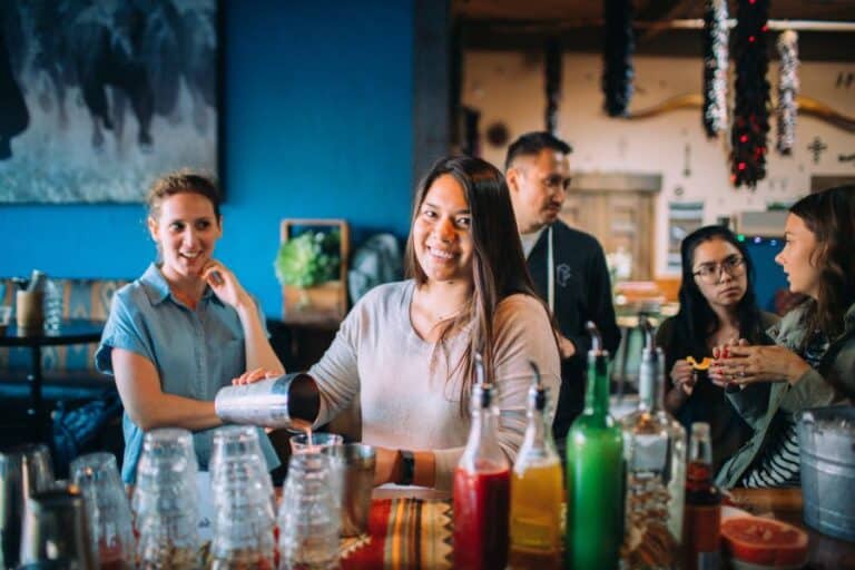 woman using a cocktail shaker to make her own cocktail in the Mission District of San Francisco