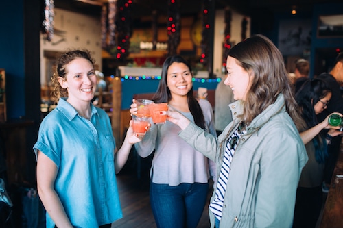 women toasting cocktails during corporate team building event