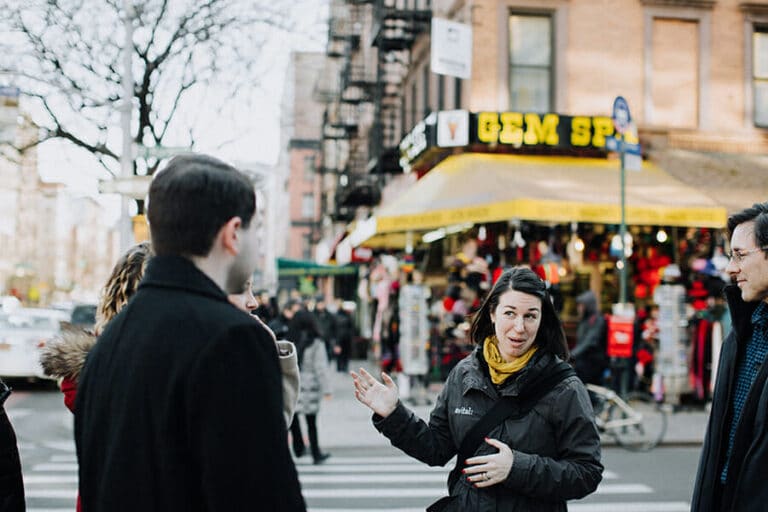 Dacia-Pierson.-East-Village-Food-Tour.-Avital-pointing-to-Gem-Spa-in-EAst-Village-with-group-copy