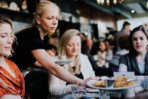 Dacia-Pierson.-East-Village-Food-Tour.-Server-serving-Pierogis-to-guests-at-table-copy