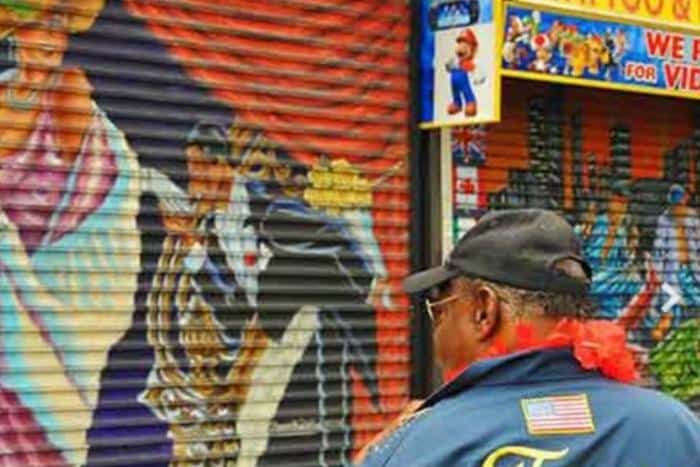 man looking at mural during harlem food tour in nyc