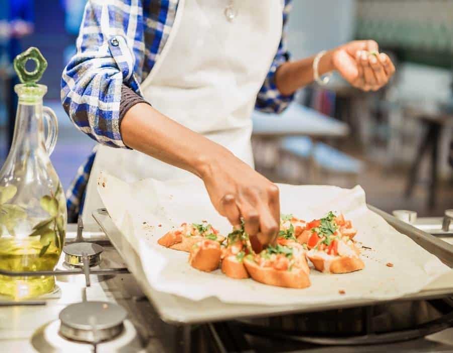 woman making bruschetta during cooking class in nyc