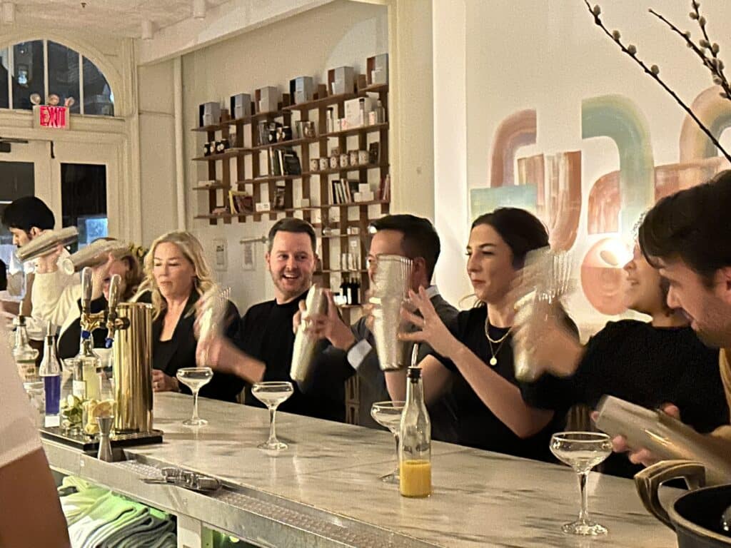 nyc group dining event with group shaking cocktails at il fiorista bar in new york city