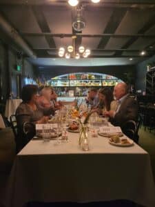 Group of Guests sitting at Long Table Eating during a Dallas Interactive Private Dining Meal