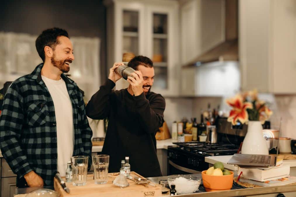 couple shaking cocktail during virtual team building event for happy hour