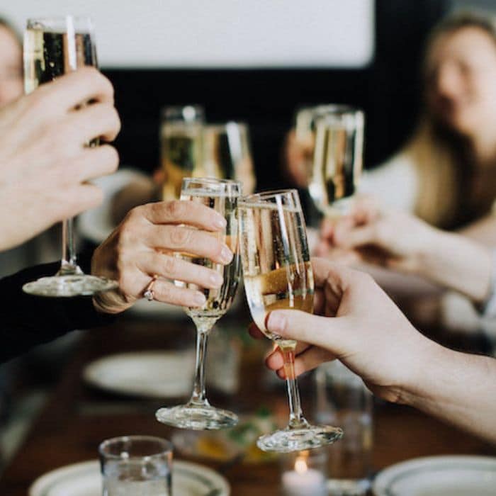 hands toasting champagne during company holiday party