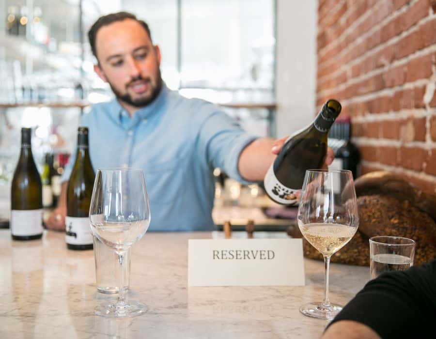 man pouring wine during nyc food tour