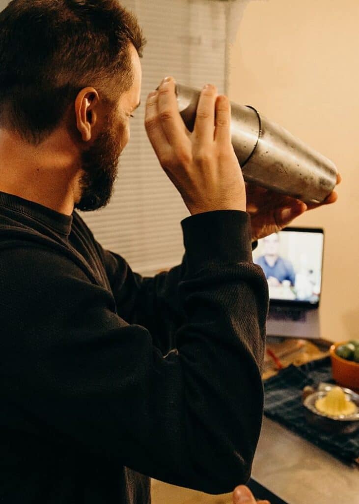 man shaking cocktail during virtual event