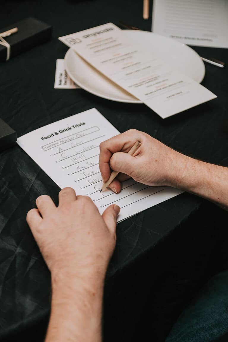 person filling out trivia sheet