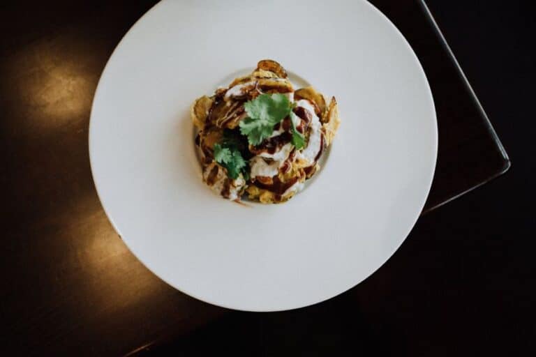 white rimmed plate of shishito peppers served during nyc michelin food tour