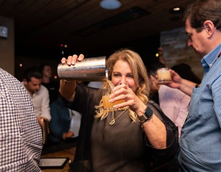 guest pouring cocktail from shaker into glass during private dining experience