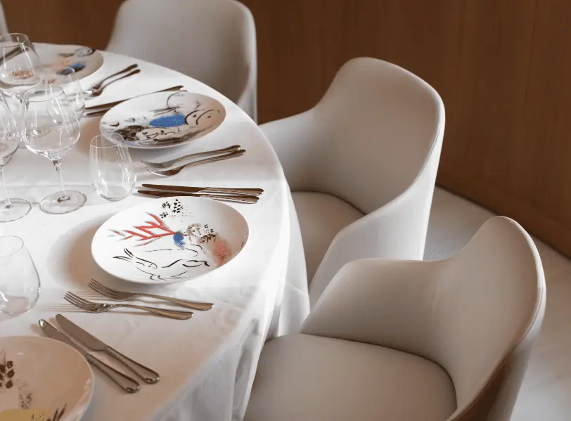 a table set with white dishes at estiatorio milos private dining room in nyc