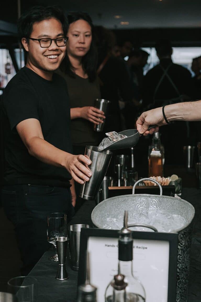 A man smiling as he participates in a cocktail-making activity, showcasing an engaging dining experience at restaurants with private rooms NYC, ideal for group events and interactive gatherings.