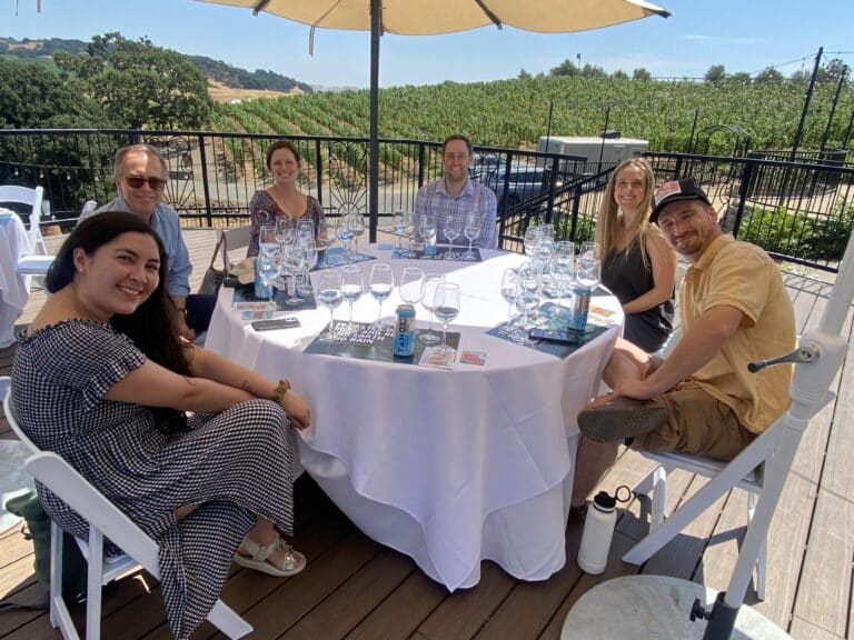 group smiling at table during guided water tasting