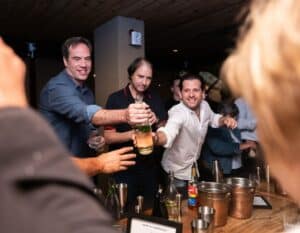 team passing bottle of alcohol during las vegas interactive meal with avital