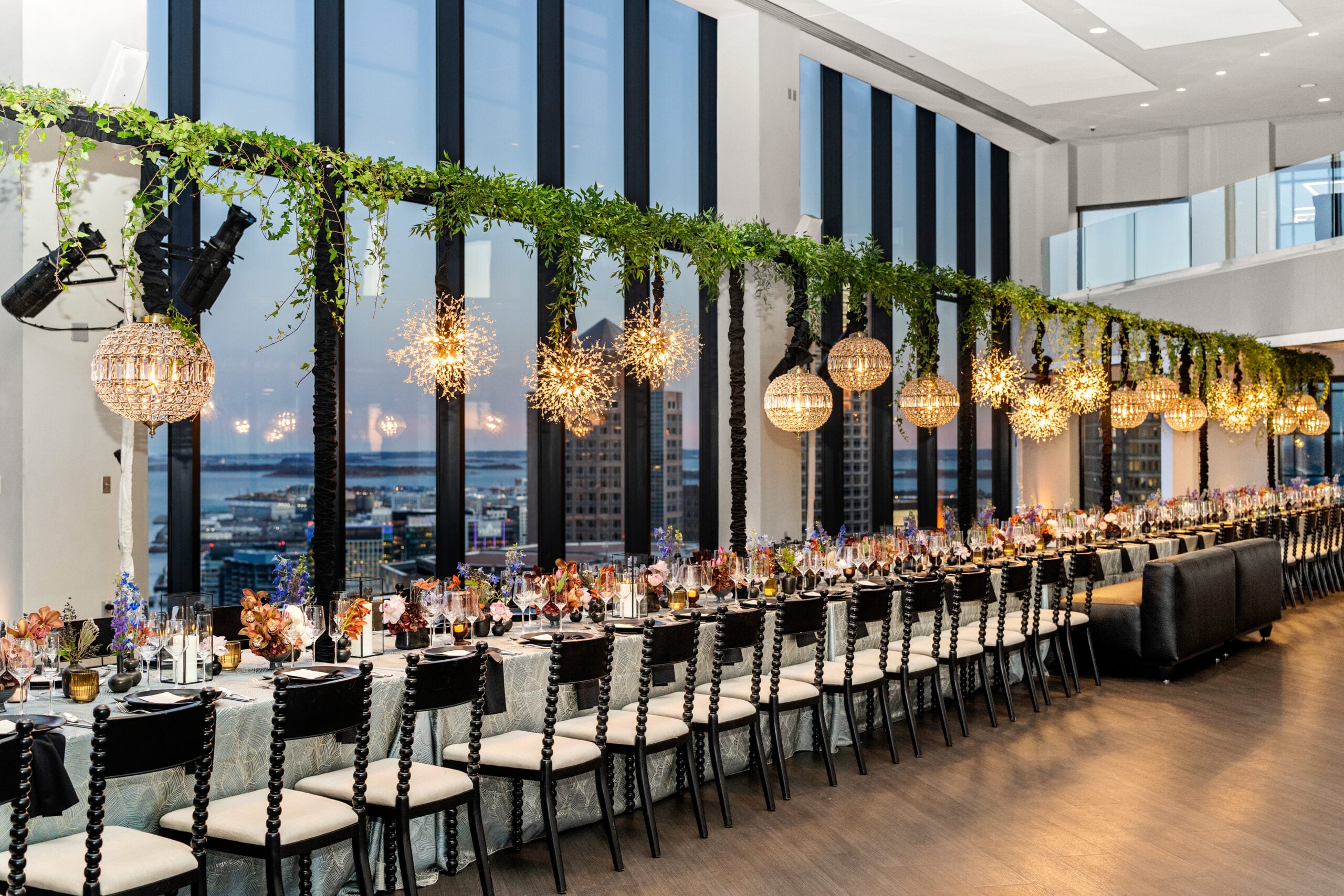 A long table is decked out with beautiul plates and flowers and lights