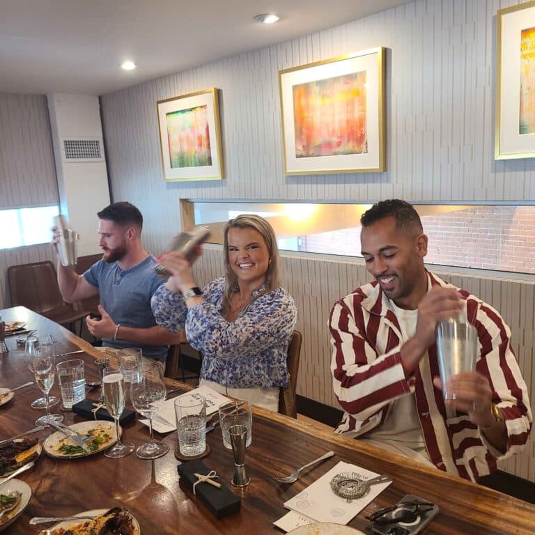 woman shaking cocktail at table with two other guests during venice interactive meal