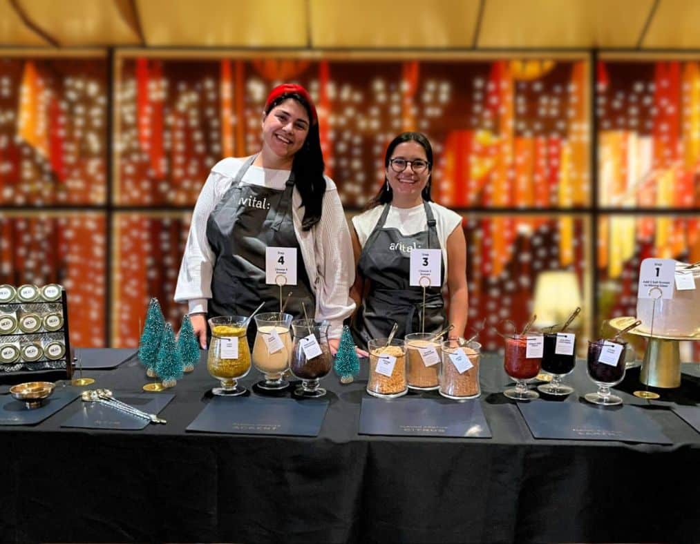 avital hosts standing in front of holiday interactive bar