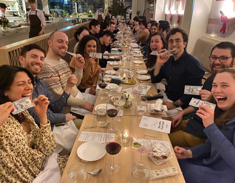 people smiling and holding edible money during group dinner nyc