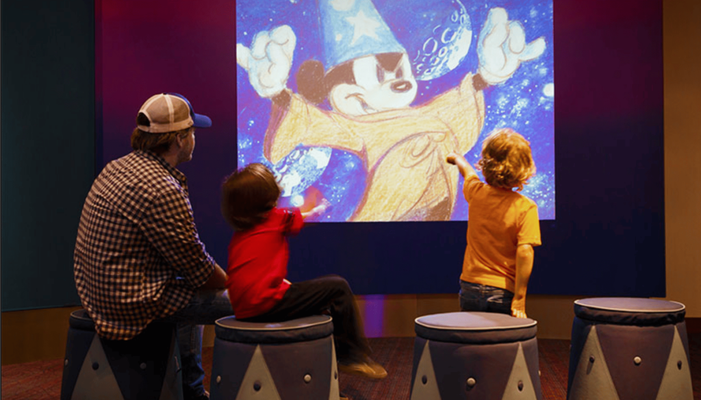 kids and dad looking at screen at walk disney museum in san francisco