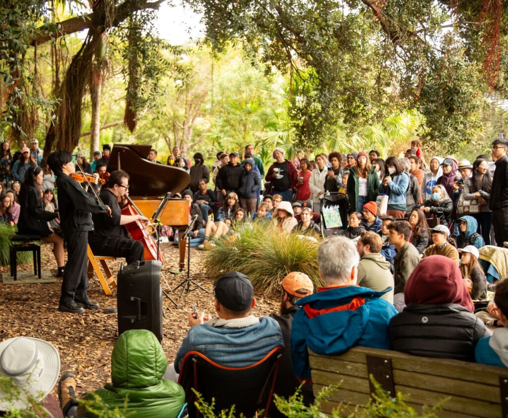group of people listening to piano at san francisco botanical garden