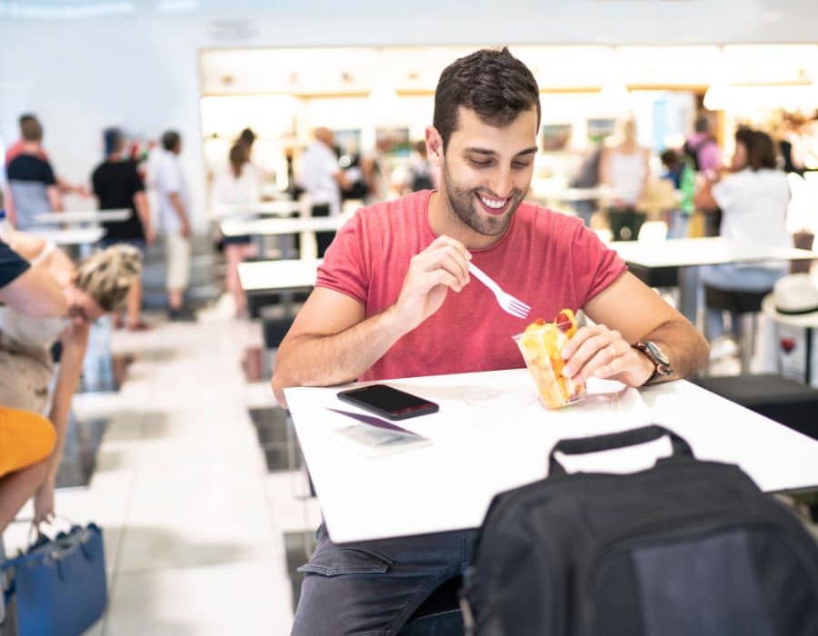 man eating fast food at table in sfo airport
