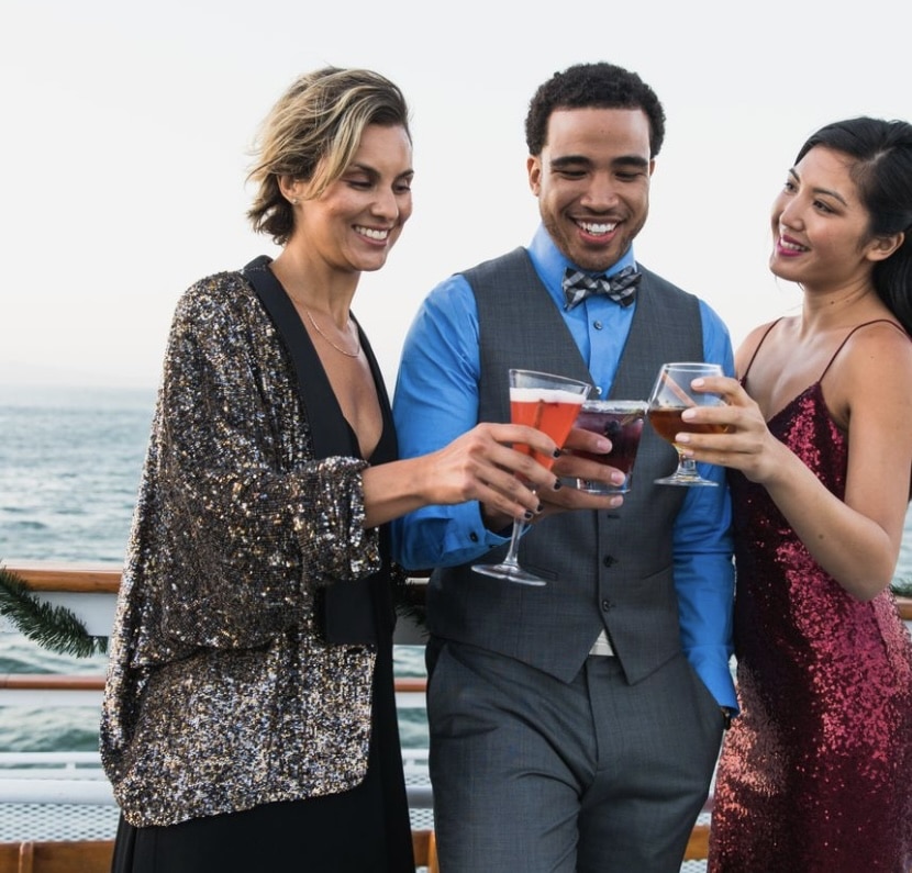 group toasting cocktails on boat during los angeles company holiday party